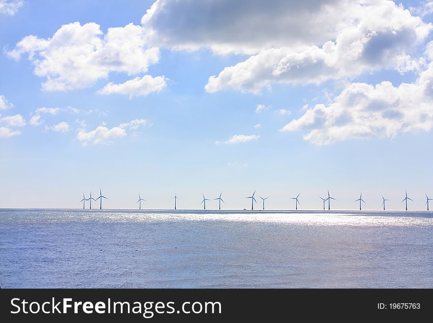 Row of wind turbines out at sea on a summers day. Row of wind turbines out at sea on a summers day
