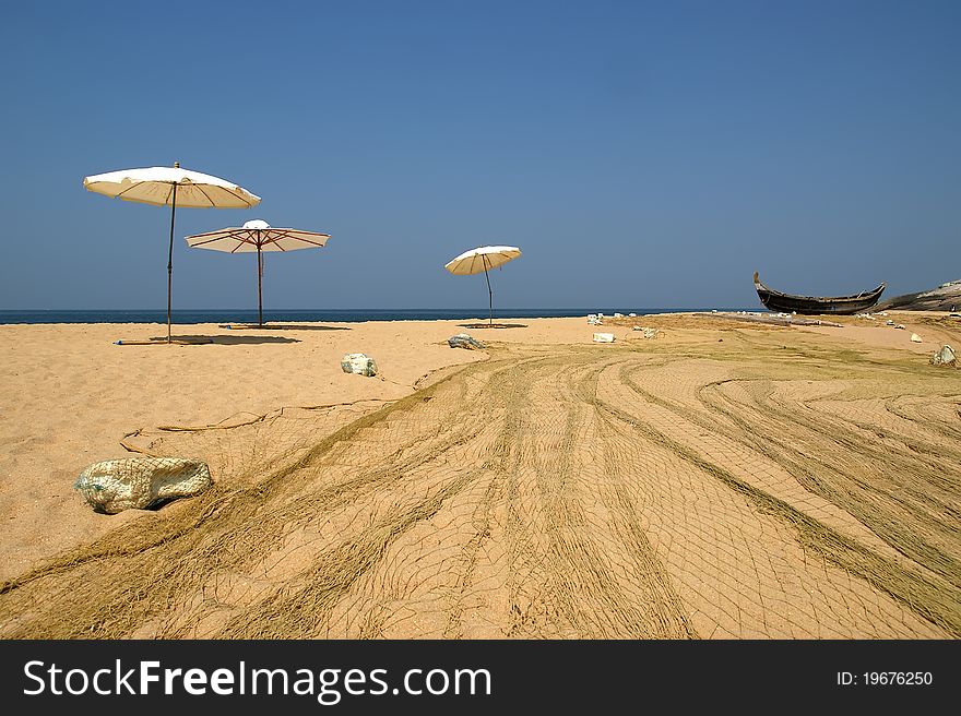 Fishing Net And Umbrellas Sol On The Beach