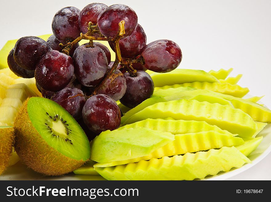 The fruits include kiwi ,mango and grape in white background