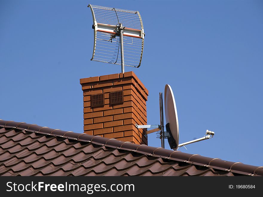 White satellite dish on brown roof. White satellite dish on brown roof