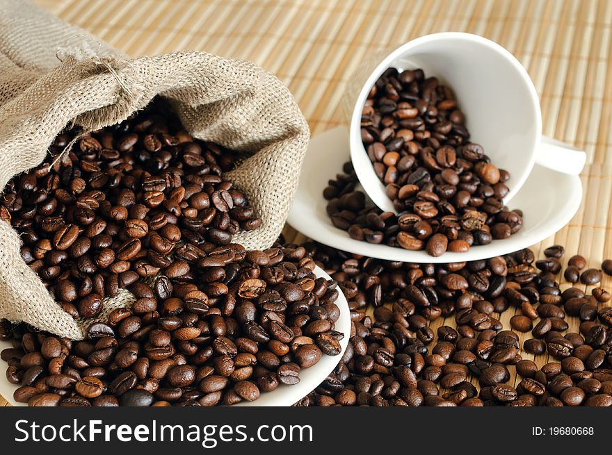 Coffee beans with a white cup and sack