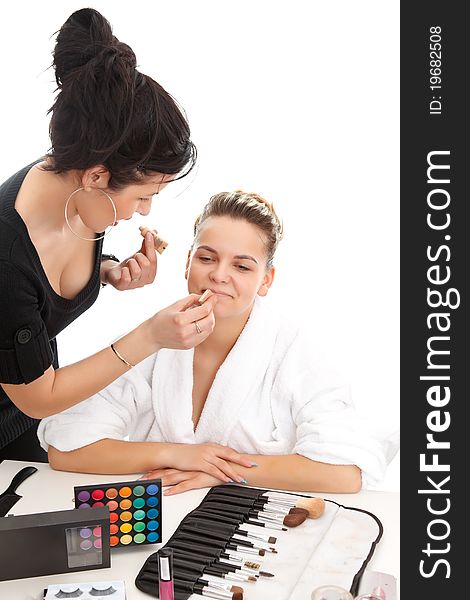 Cosmetologist doing makeup to a young client. Cosmetologist doing makeup to a young client