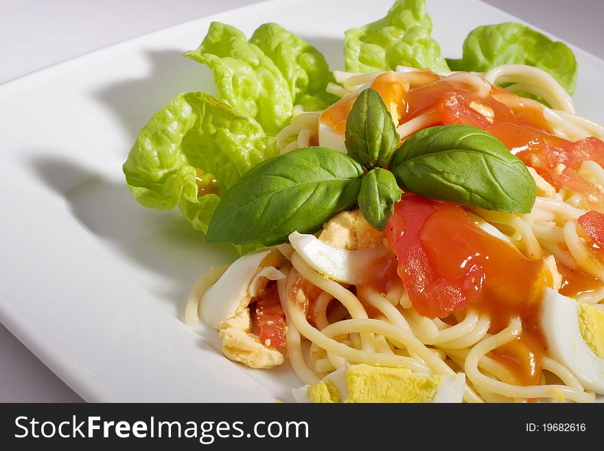 Pasta with tomato sauce, egg, tomato and basil.