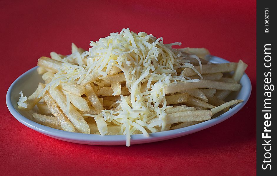 Crunchy french fries with chese on a white plate. Crunchy french fries with chese on a white plate