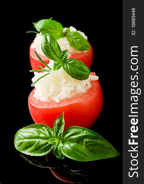 Photo of delicious stuffed tomatoes with rice on black isolated background. Photo of delicious stuffed tomatoes with rice on black isolated background