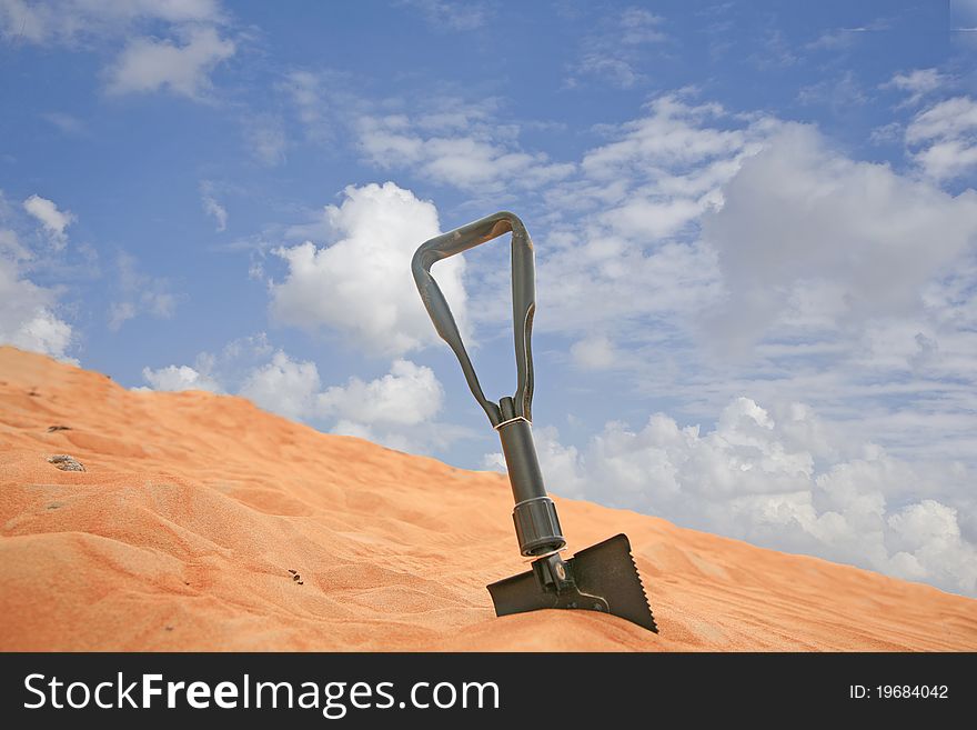 Shovel stuck in the desert dunes