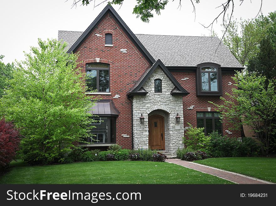 Image of a single family home with many windows and beautiful landscaping. Image of a single family home with many windows and beautiful landscaping.