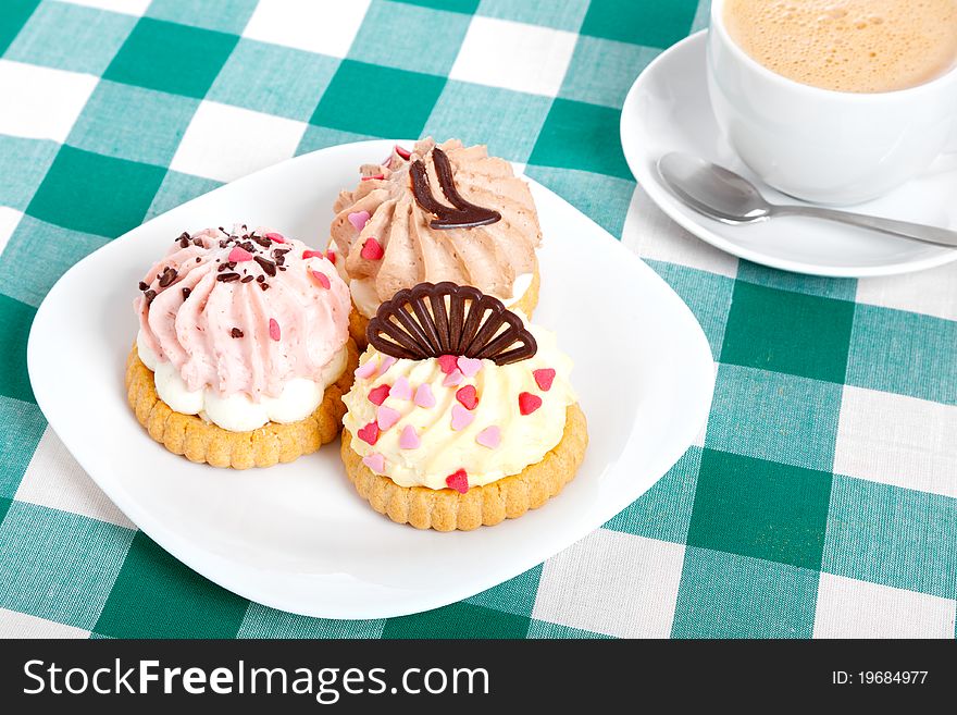 Three cake on tablecloth. Coffee cup