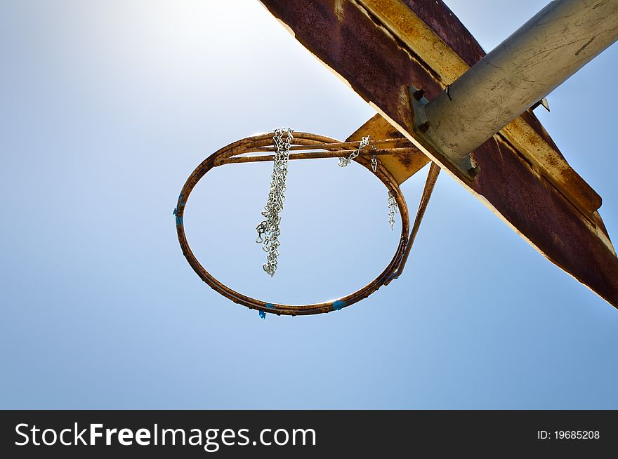 Weathered basketball board against blue sky background