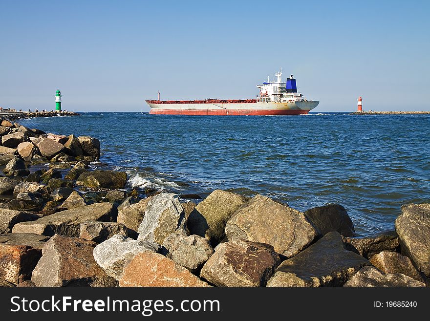 A cargo ship passes by the lighthouses of Warnemuende.