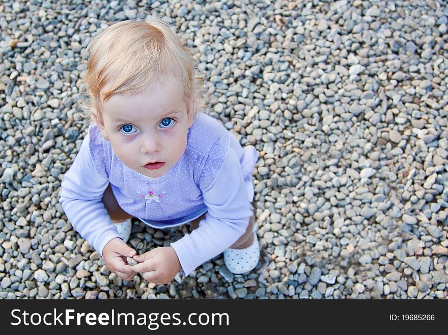 Blue eyes baby playing outdoor with stones. Blue eyes baby playing outdoor with stones