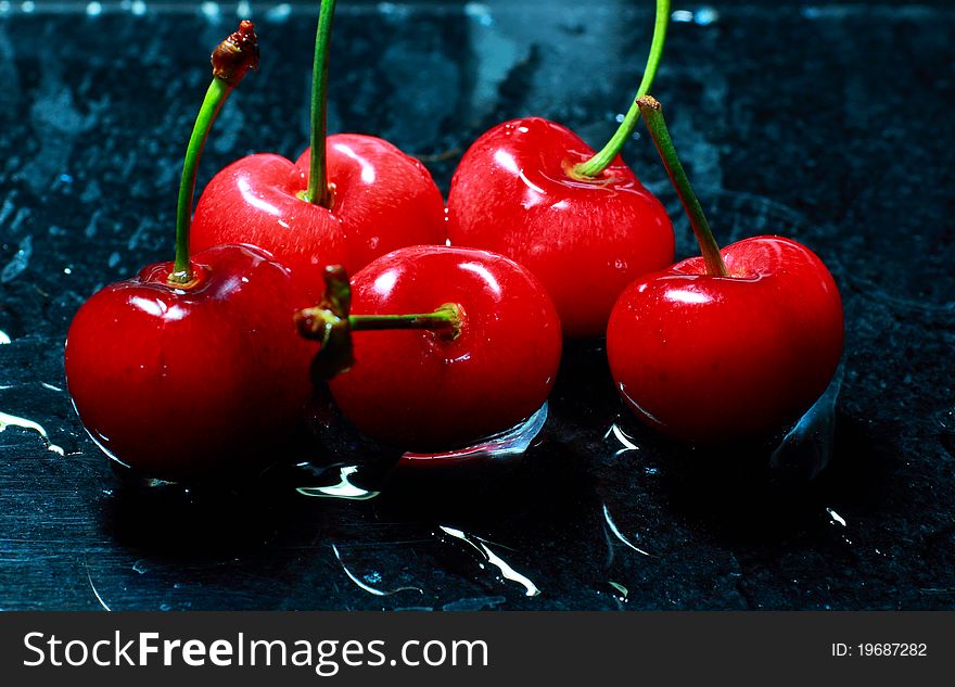 Red cherry on black background.