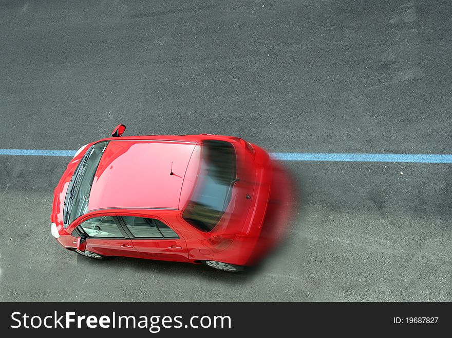 A red car moving on the road view from high