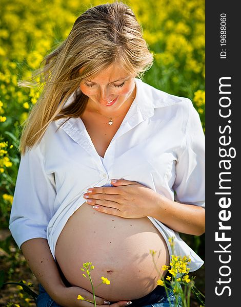 Pregnant woman sitting on green field