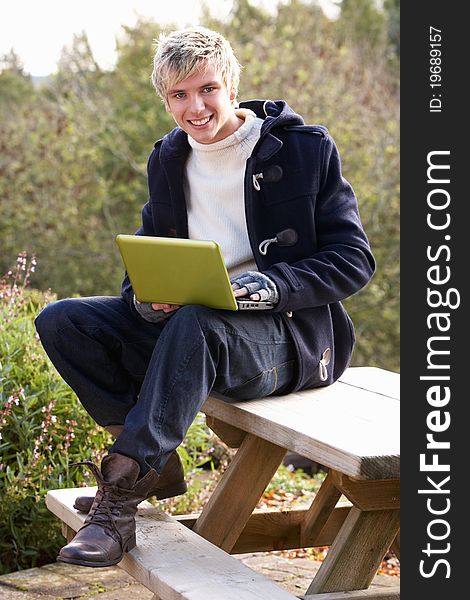 Young man with laptop computer smiling