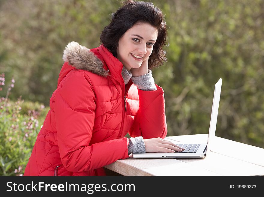 Young woman with laptop computer smiling at camera