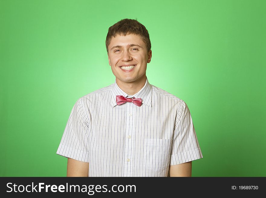 Handsome young man in a shirt with a green background smiling at the camera. Botanica. Handsome young man in a shirt with a green background smiling at the camera. Botanica