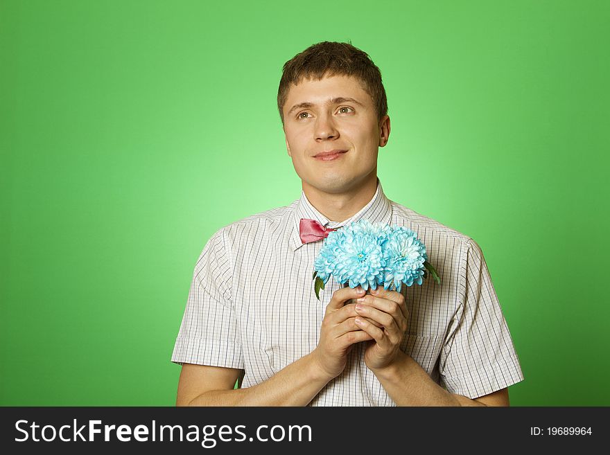 Parody lover man nerd in a shirt and tie butterfly with a bouquet of flowers blue chrysanthemums. Parody lover man nerd in a shirt and tie butterfly with a bouquet of flowers blue chrysanthemums
