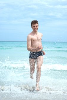 Happy Man Running From The Ocean Stock Photo