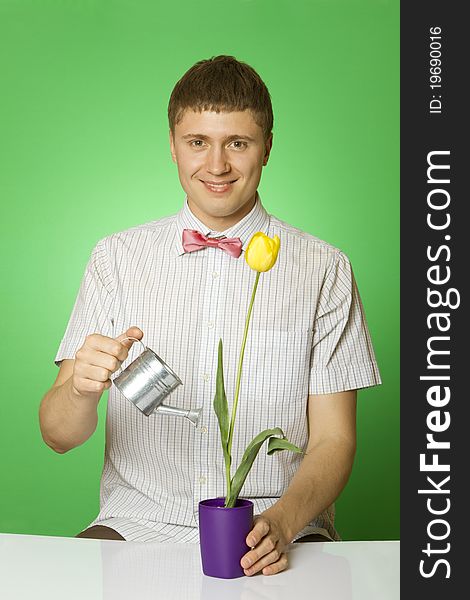 Parody lover man nerd in a shirt and tie bow tie waters from Lake rostuschy tulip in a pot. Parody lover man nerd in a shirt and tie bow tie waters from Lake rostuschy tulip in a pot