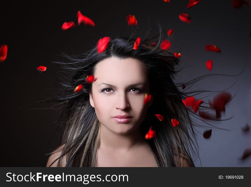 Woman And Flying Leaves Of Red Roses
