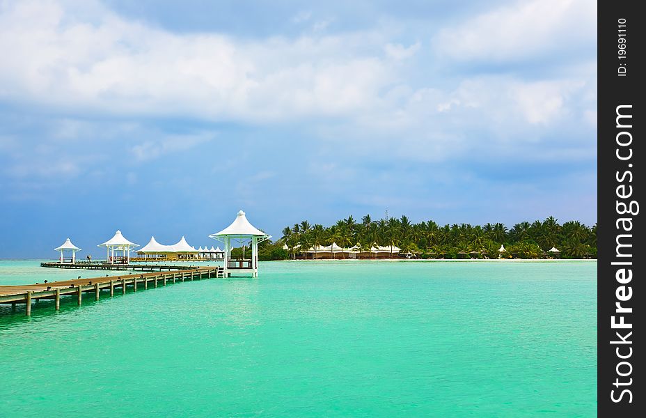 Jetty on a tropical beach - Maldives travel background. Jetty on a tropical beach - Maldives travel background