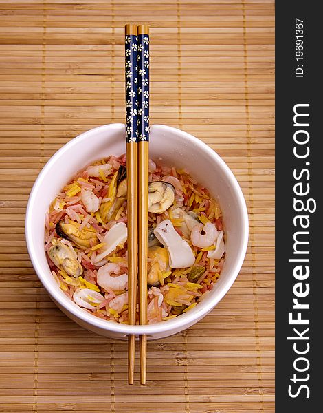 Fragrant rice and seafood in a bowl with chopsticks, ready to be eaten. Fragrant rice and seafood in a bowl with chopsticks, ready to be eaten.