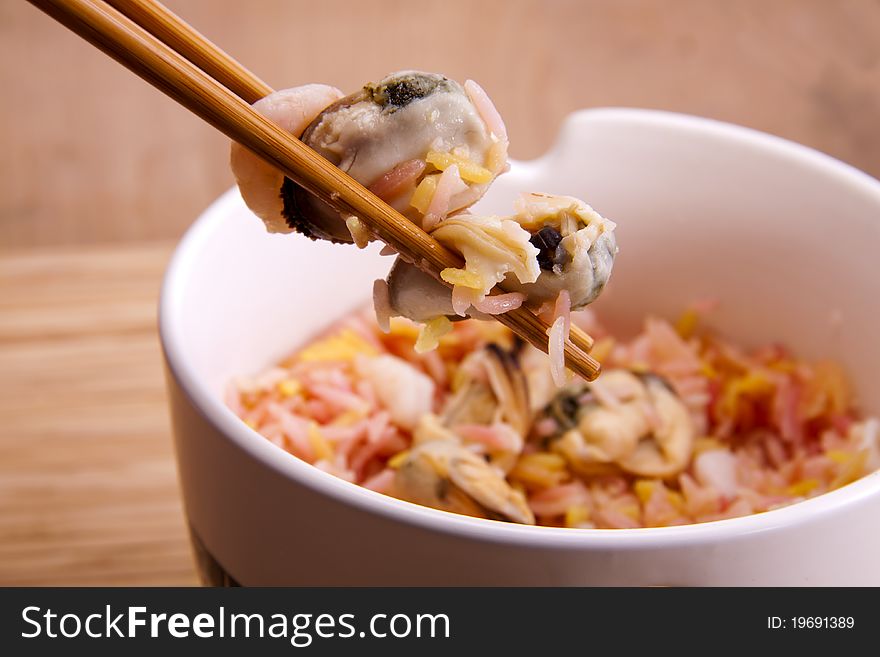 Fragrant rice and seafood in a bowl with chopsticks, ready to be eaten. Fragrant rice and seafood in a bowl with chopsticks, ready to be eaten.