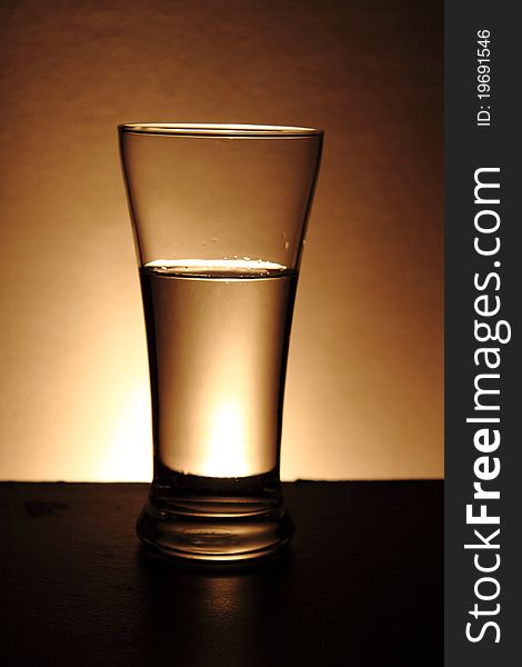 Water in a glass isolated on a gold background. Water in a glass isolated on a gold background.