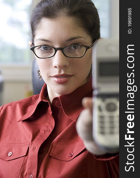 Young businesswoman holding cellphone with glasses