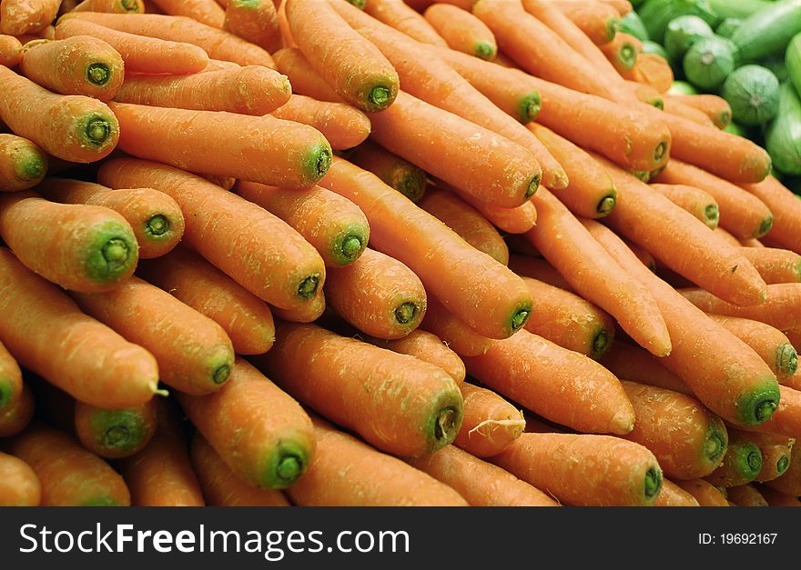 Carrots and some marrows on the back in a supermarket stand. Carrots and some marrows on the back in a supermarket stand