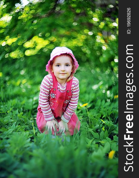 Playful little girl in hat on grass. may day
