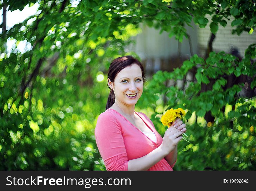 Future mom with bouquet of dandelions. spring day