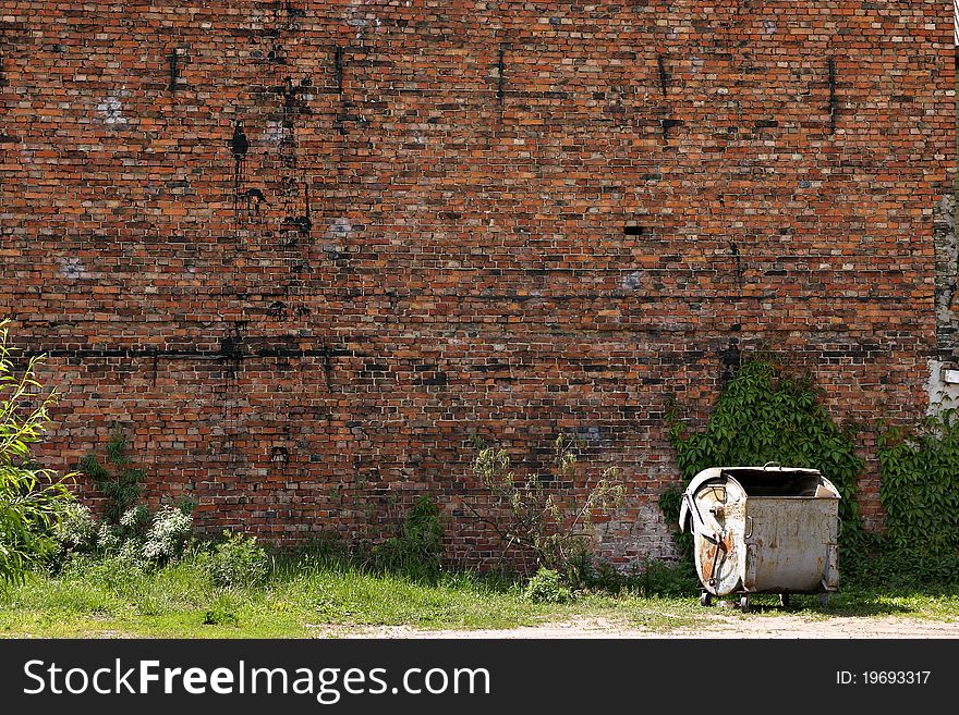 Garbage can by the red brick wall in the city. Garbage can by the red brick wall in the city.