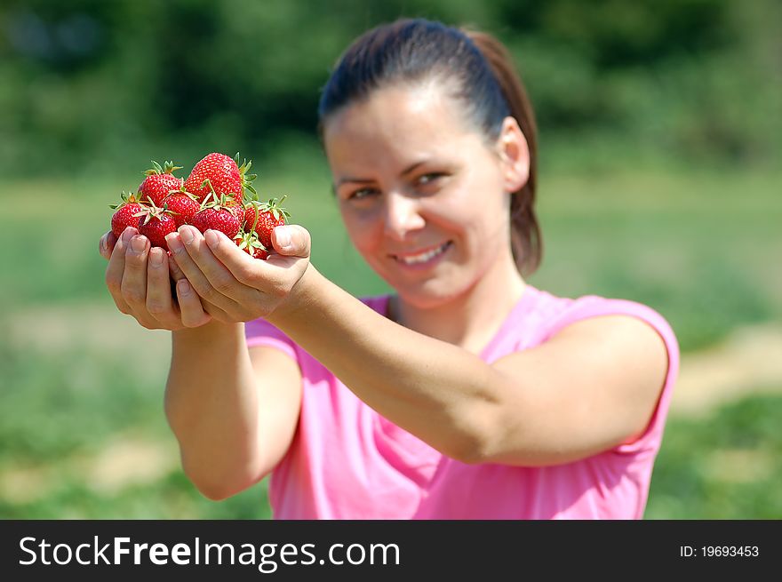 Fresh picked strawberries held by a pretty girl