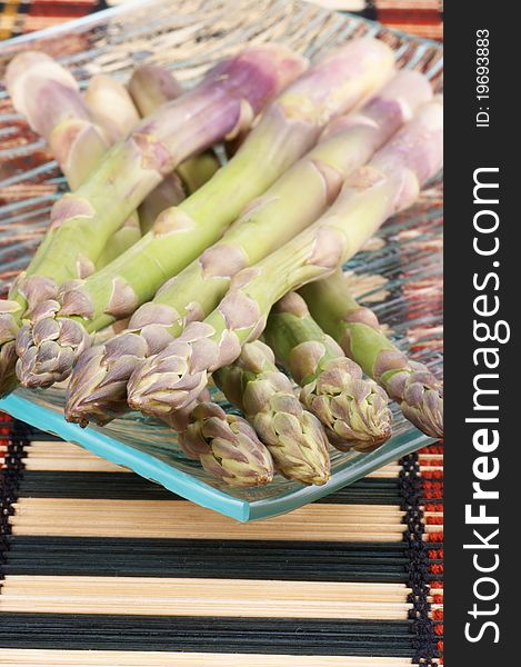 Raw asparagus on a glass plate