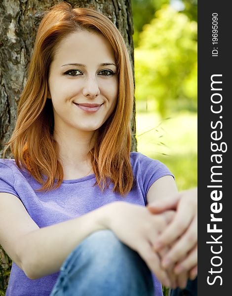 Beautiful redhead girl at the park in summer time.