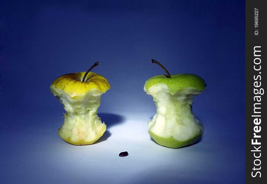 Two leftover bits of apple, as character of finale of life and one seed of apple as character of new life. Two leftover bits of apple, as character of finale of life and one seed of apple as character of new life