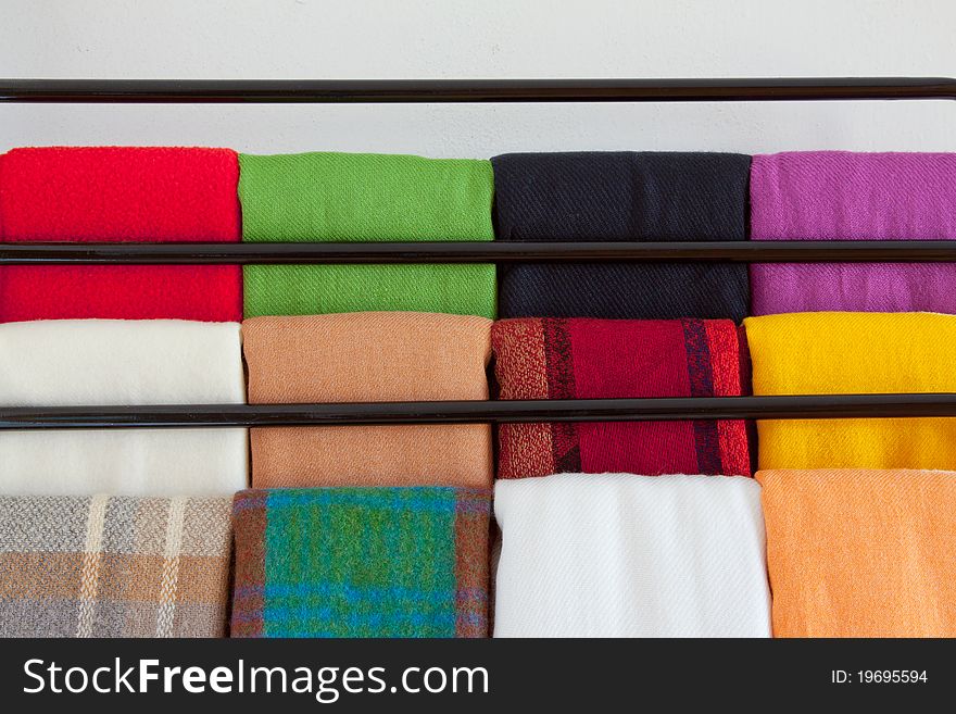 Twelve scarves on a rack