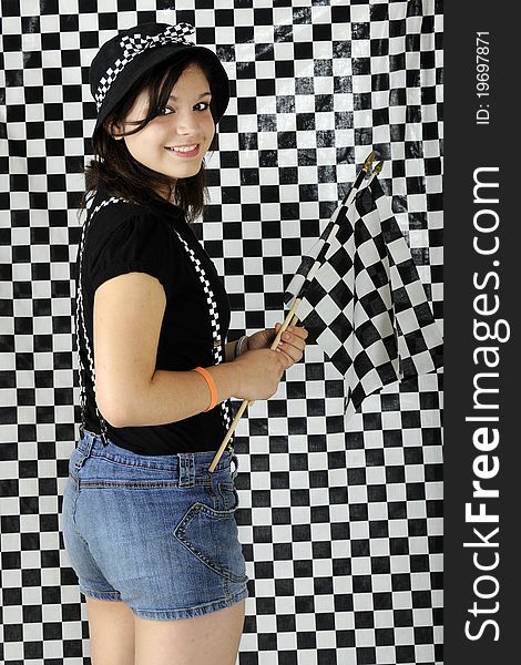 An attractive young teen racing fan holding racing's checkered flag before a black and white checked background. An attractive young teen racing fan holding racing's checkered flag before a black and white checked background.