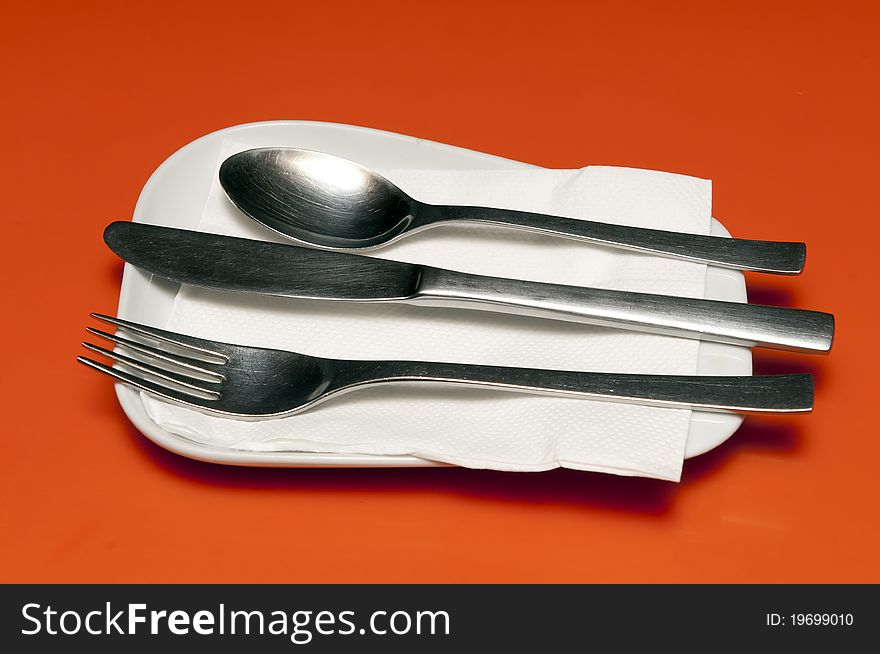 Spoon, fork and tissue set on a resturant table. Spoon, fork and tissue set on a resturant table