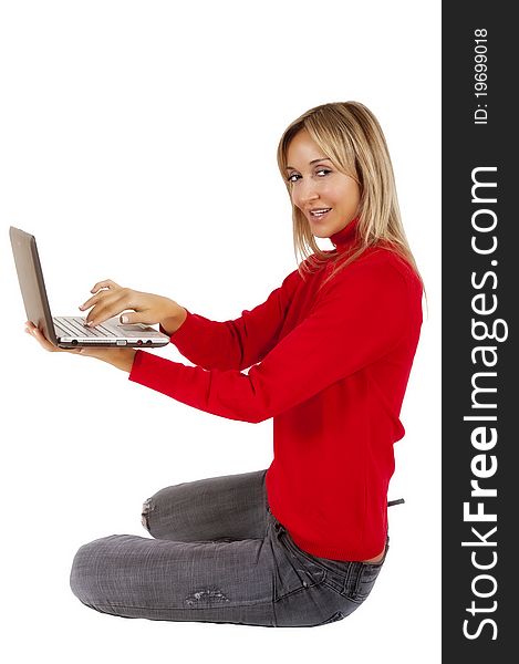 Happy working woman sitting on the floor with her laptop