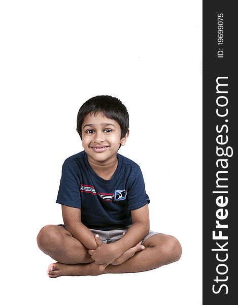 An handsome Indian kid sitting and smiling