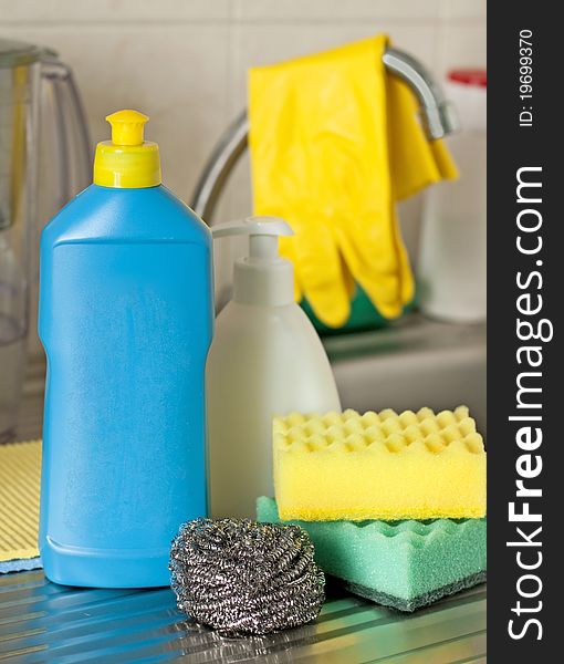 Bottles, sponges on foreground on kitchen