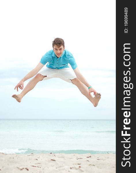 Young man jumping high on the beach