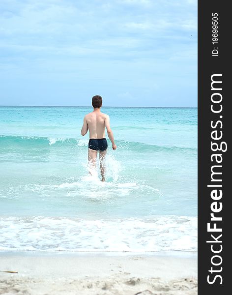 Happy man running into ocean waves. Happy man running into ocean waves