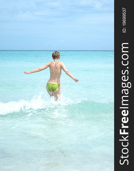 Young Woman Running Into The Ocean