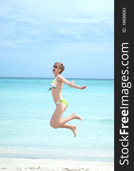 Young woman jumping high on the beach