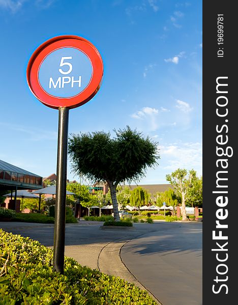 Five miles per hour sign against blue sky in shopping mall