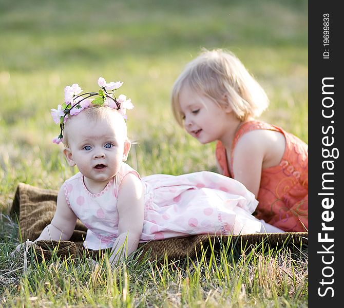 Two little girls sitting on the grass